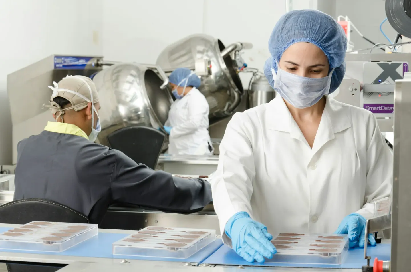 A food production line, staff in coats and hairnets